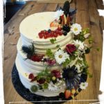 Hochzeitstorte in Streifenoptik mit vielen Blumen