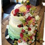 Hochzeitstorte in Streifenoptik mit bunten Blumen